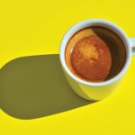 Një filxhan kafe në një tryezë në diell